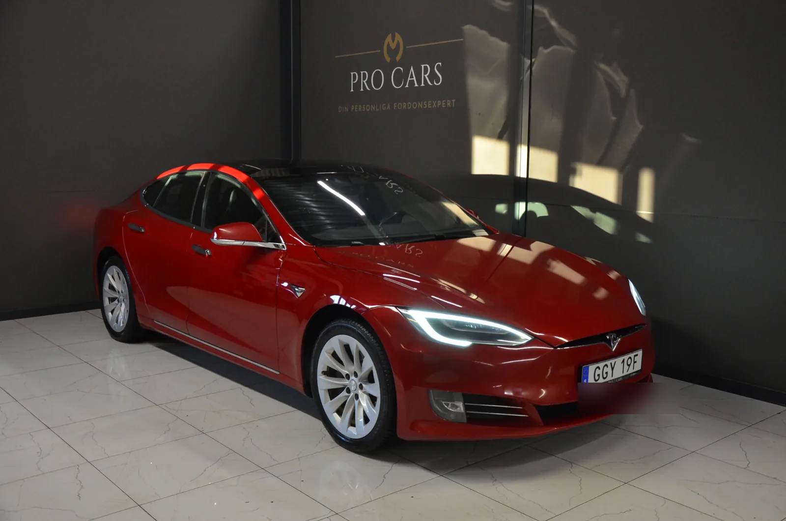 Svart Tesla Model S framför Pro Cars-logotypen i showroomet