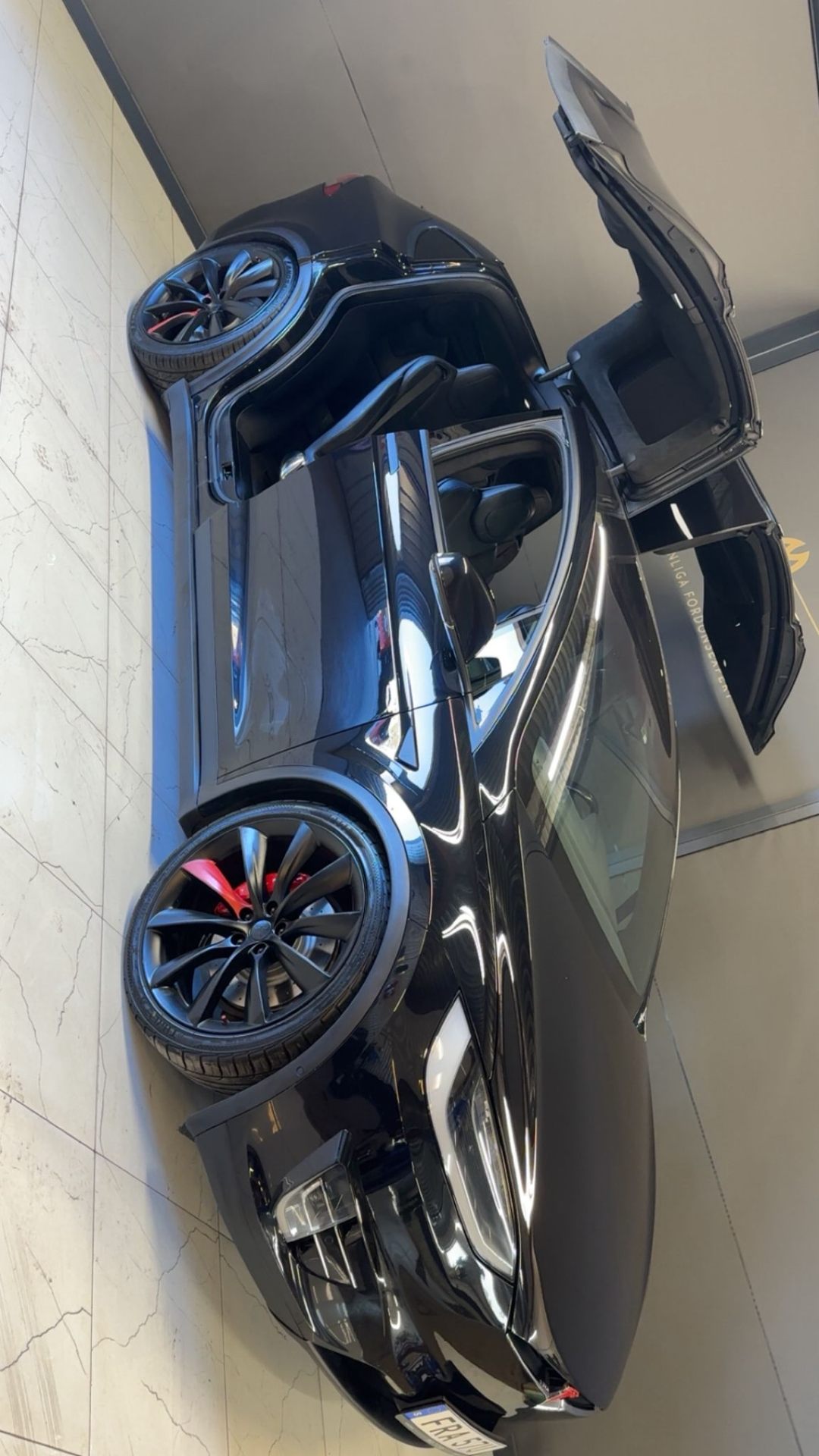Svart Tesla Model X med öppna falcon-wing-dörrar i Pro Cars showroom Linköping